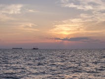 Un tramonto sopra il mare con due siluette delle navi fotografia stock Un tramonto sopra il mare con due siluette delle navi fotografia stock