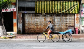 Un tricycle d'équitation d'homme sur la rue dans Chaudok, Vietnam image libre de droits Un tricycle d'équitation d'homme sur la rue dans Chaudok, Vietnam image libre de droits