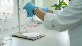 Un técnico de laboratorio está mezclando las sustancias químicas en frascos metrajes Un técnico de laboratorio está mezclando las sustancias químicas en frascos metrajes