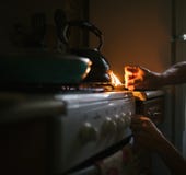 Un uomo accende una partita su una stufa di gas con una partita fotografia stock libera da diritti Un uomo accende una partita su una stufa di gas con una partita fotografia stock libera da diritti