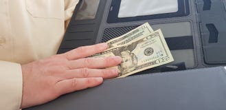 Un uomo che porta la camicia di colore chiaro ufficiale tiene il suo giusto NAND su venti dollari immagine stock libera da diritti Un uomo che porta la camicia di colore chiaro ufficiale tiene il suo giusto NAND su venti dollari immagine stock libera da diritti