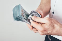 Un uomo d'affari tiene i soldi nelle suoi mani e conteggi il suo reddito I soldi sono impilati nelle banconote in dollari fotografia stock libera da diritti Un uomo d'affari tiene i soldi nelle suoi mani e conteggi il suo reddito I soldi sono impilati nelle banconote in dollari fotografia stock libera da diritti