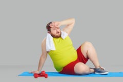 Un uomo grasso in abiti sportivi ha stancato un fondo grigio fotografie stock libere da diritti Un uomo grasso in abiti sportivi ha stancato un fondo grigio fotografie stock libere da diritti