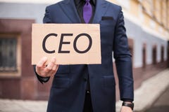 Un uomo mostra una compressa del cartone con il CEO della parola ? fotografia stock Un uomo mostra una compressa del cartone con il CEO della parola ? fotografia stock