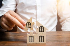 Un uomo raccoglie una casa dei puzzle Costruzione del vostro proprio edificio residenziale Mutuo ipotecario, espansione residenzi fotografia stock libera da diritti Un uomo raccoglie una casa dei puzzle Costruzione del vostro proprio edificio residenziale Mutuo ipotecario, espansione residenzi fotografia stock libera da diritti