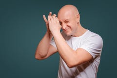 Un uomo su un fondo blu nel tenersi per mano vicino ai suoi occhi come i pigoli di un telescopio immagini stock Un uomo su un fondo blu nel tenersi per mano vicino ai suoi occhi come i pigoli di un telescopio immagini stock