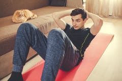 Un uomo va dentro per gli sport a casa sul pavimento con il gatto Scuote la stampa fotografia stock libera da diritti Un uomo va dentro per gli sport a casa sul pavimento con il gatto Scuote la stampa fotografia stock libera da diritti