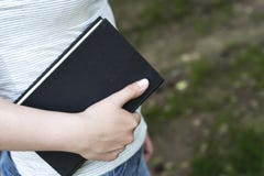 Un vecchio libro nella vista laterale della mano di una donna, spazio della copia, concetto di immagine stock Un vecchio libro nella vista laterale della mano di una donna, spazio della copia, concetto di immagine stock