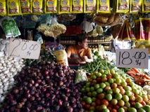 Un venditore del mercato dentro una frutta e una verdura si blocca in un mercato pubblico immagini stock libere da diritti Un venditore del mercato dentro una frutta e una verdura si blocca in un mercato pubblico immagini stock libere da diritti