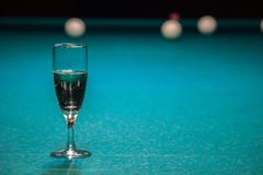 Un verre de champagne est sur la table de billard le gagnant du jeu, le champion boit un verre de vin mousseux Passe-temps, sport image libre de droits Un verre de champagne est sur la table de billard le gagnant du jeu, le champion boit un verre de vin mousseux Passe-temps, sport image libre de droits