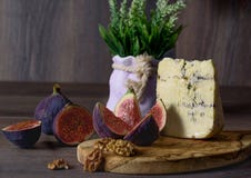 Un verre de vin rouge avec des casse-croûte de fromage, des raisins des figues et du NU photographie stock libre de droits Un verre de vin rouge avec des casse-croûte de fromage, des raisins des figues et du NU photographie stock libre de droits