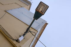 Un vieux courrier accrochant rouillé de lampe avec des fils dans lui Placé au-dessus de la lumière collored le mur à l'extérieur image libre de droits Un vieux courrier accrochant rouillé de lampe avec des fils dans lui Placé au-dessus de la lumière collored le mur à l'extérieur image libre de droits