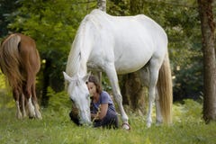 Una amazona joven con su caballo blanco que muestra al enlace los tienen gracias a la doma natural en un bosque en Pontevedra, Es fotografía de archivo libre de regalías Una amazona joven con su caballo blanco que muestra al enlace los tienen gracias a la doma natural en un bosque en Pontevedra, Es fotografía de archivo libre de regalías