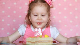 Una bambina dolce fa un desiderio e spegne le candele sulla torta di compleanno al partito Bambino sveglio Il concetto di un ` s video d archivio Una bambina dolce fa un desiderio e spegne le candele sulla torta di compleanno al partito Bambino sveglio Il concetto di un ` s video d archivio