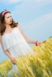 Una bella giovane donna su un giacimento di grano Immagini Stock Libere da Diritti Una bella giovane donna su un giacimento di grano Immagini Stock Libere da Diritti