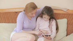 Una bella madre e la sua piccola conversazione della figlia bene, la madre tiene una compressa ed insegna a sua figlia video d archivio Una bella madre e la sua piccola conversazione della figlia bene, la madre tiene una compressa ed insegna a sua figlia video d archivio