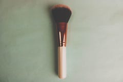 Una bella spazzola molle per trucco da pelo naturale per bellezza che mira e che applica ad una base tonale con una penna di legn fotografia stock libera da diritti Una bella spazzola molle per trucco da pelo naturale per bellezza che mira e che applica ad una base tonale con una penna di legn fotografia stock libera da diritti