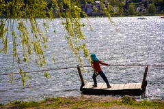 Una chica joven se tira a lo largo de la costa en una balsa y una cuerda imágenes de archivo libres de regalías Una chica joven se tira a lo largo de la costa en una balsa y una cuerda imágenes de archivo libres de regalías