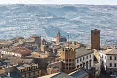 Una ciudad italiana de la cumbre se sienta arriba sobre el campo en la distancia fotografía de archivo libre de regalías Una ciudad italiana de la cumbre se sienta arriba sobre el campo en la distancia fotografía de archivo libre de regalías