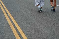 Una coppia che corre giù il boulevard del porto durante conquista la corsa del ponte immagine stock Una coppia che corre giù il boulevard del porto durante conquista la corsa del ponte immagine stock