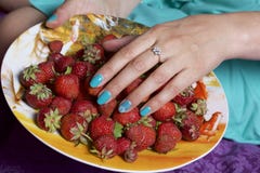 Una donna prende lo strawberrie da un piatto r Fotografia Stock Una donna prende lo strawberrie da un piatto r Fotografia Stock