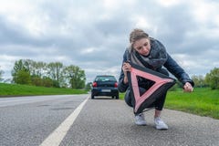 Una donna sta provando a sviluppare il suo triangolo d'avvertimento immagine stock libera da diritti Una donna sta provando a sviluppare il suo triangolo d'avvertimento immagine stock libera da diritti