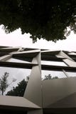 Una fachada de un edificio moderno de Berlín y la corona de un árbol fotos de archivo Una fachada de un edificio moderno de Berlín y la corona de un árbol fotos de archivo
