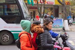 Una famiglia cinese sul motorino Immagine Stock Una famiglia cinese sul motorino Immagine Stock