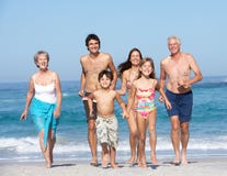 Una famiglia delle tre generazioni in vacanza sulla spiaggia fotografia stock Una famiglia delle tre generazioni in vacanza sulla spiaggia fotografia stock