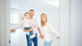 Una familia feliz abre la puerta en su apartamento fotos de archivo libres de regalías Una familia feliz abre la puerta en su apartamento fotos de archivo libres de regalías