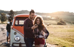 Una giovane coppia su un roadtrip attraverso la campagna, facendo uso della mappa sullo smartphone immagine stock libera da diritti Una giovane coppia su un roadtrip attraverso la campagna, facendo uso della mappa sullo smartphone immagine stock libera da diritti