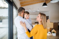 Una giovane famiglia con una ragazza del bambino che si muove nella nuova casa fotografia stock Una giovane famiglia con una ragazza del bambino che si muove nella nuova casa fotografia stock