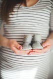 Una mano está sosteniendo un par de pequeños zapatos Él ` s zapatos para el niño en fondo gris Tema de la madre y del bebé Mujer fotos de archivo Una mano está sosteniendo un par de pequeños zapatos Él ` s zapatos para el niño en fondo gris Tema de la madre y del bebé Mujer fotos de archivo