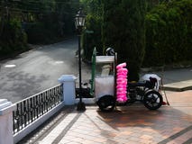 Una motocicleta modificada para requisitos particulares para vender el caramelo de algodón rosado en el atrio de una iglesia cató fotografía de archivo libre de regalías Una motocicleta modificada para requisitos particulares para vender el caramelo de algodón rosado en el atrio de una iglesia cató fotografía de archivo libre de regalías