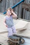 Una muchacha adorable que se sienta feliz en un pequeño barco de fila al lado de los posts del amarre fotos de archivo libres de regalías Una muchacha adorable que se sienta feliz en un pequeño barco de fila al lado de los posts del amarre fotos de archivo libres de regalías