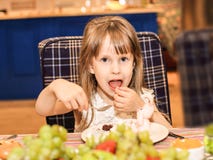 Una muchacha de cuatro años come una torta de cumpleaños imagen de archivo libre de regalías Una muchacha de cuatro años come una torta de cumpleaños imagen de archivo libre de regalías