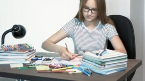 Una muchacha del adolescente con los vidrios se está sentando en un escritorio de la escuela Aprendizaje de concepto almacen de metraje de vídeo Una muchacha del adolescente con los vidrios se está sentando en un escritorio de la escuela Aprendizaje de concepto almacen de metraje de vídeo