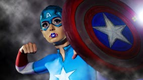 Una muchacha encantadora con el arte de cuerpo de capitán America imágenes de archivo libres de regalías Una muchacha encantadora con el arte de cuerpo de capitán America imágenes de archivo libres de regalías