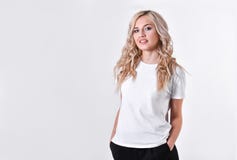 Una muchacha hermosa joven rubia se coloca con las manos dobladas foto de archivo Una muchacha hermosa joven rubia se coloca con las manos dobladas foto de archivo