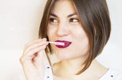 Una muchacha hermosa y sonriente goza de una piruleta 2019 imagen de archivo libre de regalías Una muchacha hermosa y sonriente goza de una piruleta 2019 imagen de archivo libre de regalías