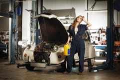 Una mujer atractiva que lava un coche en un garaje fotos de archivo Una mujer atractiva que lava un coche en un garaje fotos de archivo