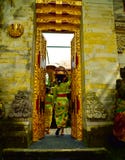 Una mujer del Balinese que lleva la ropa local tradicional que entra en un templo sagrado fotos de archivo Una mujer del Balinese que lleva la ropa local tradicional que entra en un templo sagrado fotos de archivo