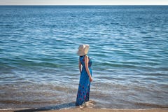 Una mujer en el sombrero en la playa fotografía de archivo libre de regalías Una mujer en el sombrero en la playa fotografía de archivo libre de regalías