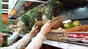 Una mujer joven elige y compra los cocos en el supermercado almacen de video Una mujer joven elige y compra los cocos en el supermercado almacen de video