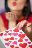 Una mujer joven hermosa toma una tarjeta con los corazones con una declaración del amor Día del `s de la tarjeta del día de San V imagen de archivo libre de regalías Una mujer joven hermosa toma una tarjeta con los corazones con una declaración del amor Día del `s de la tarjeta del día de San V imagen de archivo libre de regalías