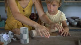 Una mujer joven y su poco hijo en una clase principal de la cerámica metrajes Una mujer joven y su poco hijo en una clase principal de la cerámica metrajes