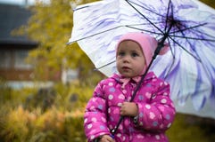Una niña camina con un paraguas en la lluvia en el país foto de archivo Una niña camina con un paraguas en la lluvia en el país foto de archivo
