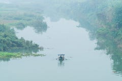 Una piccola barca sul fiume Rosso sotto il ponte lungo di Bien - inverno 2018 di Hanoi Fotografie Stock Una piccola barca sul fiume Rosso sotto il ponte lungo di Bien - inverno 2018 di Hanoi Fotografie Stock
