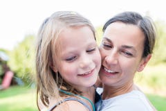 Una piccola ragazza di risata nelle armi di sua madre che fa i suoi desideri durante la festa di compleanno nel giardino immagini stock Una piccola ragazza di risata nelle armi di sua madre che fa i suoi desideri durante la festa di compleanno nel giardino immagini stock