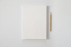 Una pila de hojas de papel en blanco y de un lápiz en un fondo blanco fotos de archivo libres de regalías Una pila de hojas de papel en blanco y de un lápiz en un fondo blanco fotos de archivo libres de regalías
